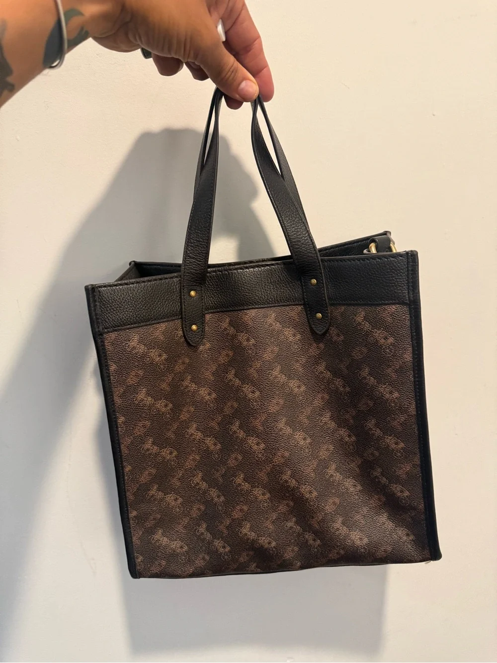 This is a Coach Field Tote in Truffle Black with a horse and carriage print